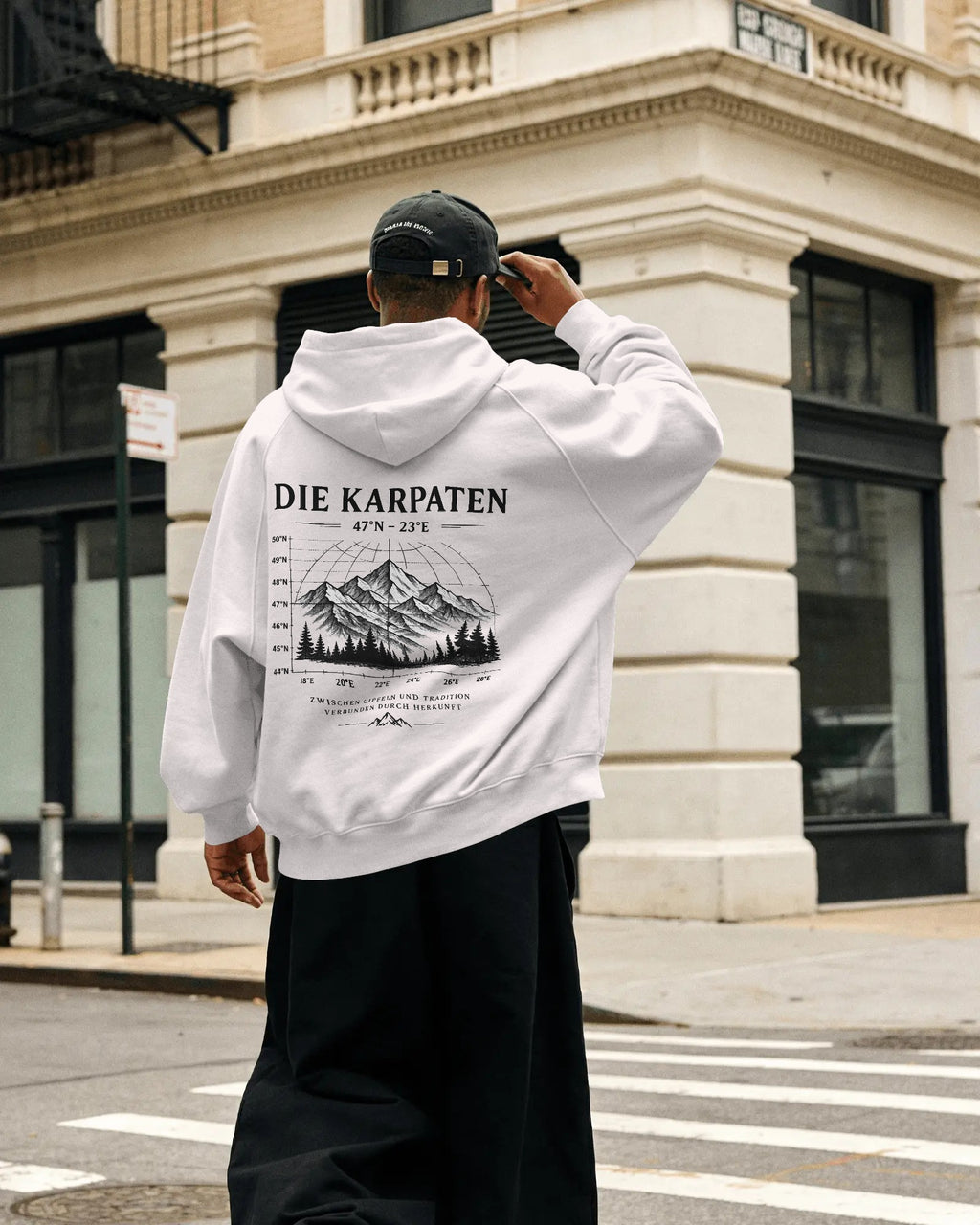 DIE KARPATEN Oversized Hoodie mit großem Karpaten-Backprint am Model in urbaner Umgebung